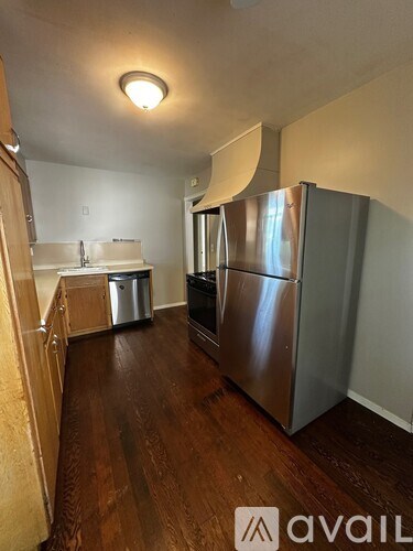 A kitchen with a refrigerator and a sink.