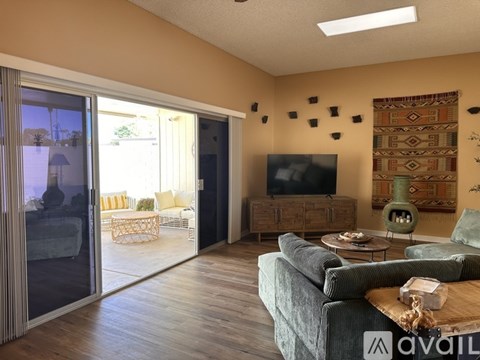 A living room with a grey couch and a television on the wall.