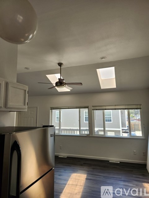 A kitchen with a stainless steel dishwasher and a ceiling fan.