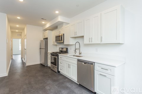 A modern kitchen with white cabinets and stainless steel appliances.