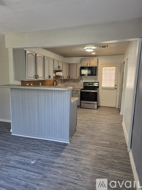 A kitchen with a white counter and grey cabinets.