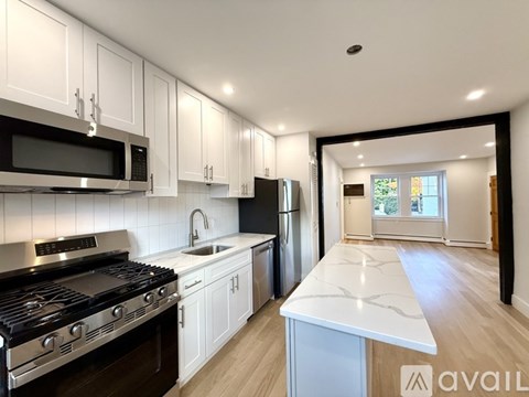 A modern kitchen with white cabinets and stainless steel appliances.