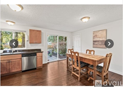 A kitchen with wooden cabinets and a dining table with chairs.