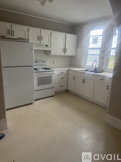 A kitchen with white appliances and cabinets.