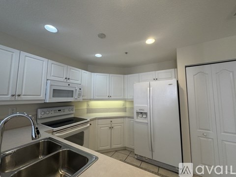 A kitchen with white cabinets and appliances.