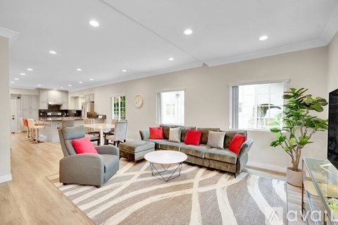 A living room with a grey sofa and a striped rug.