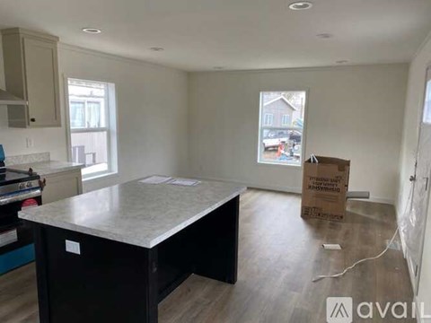A room with a kitchen island and a box on the floor.