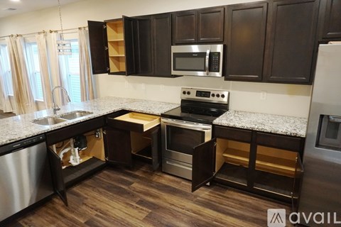 A kitchen with dark brown cabinets and a white countertop.