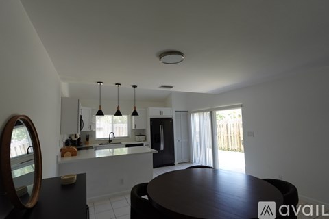 A modern kitchen with a round table and a large mirror on the wall.