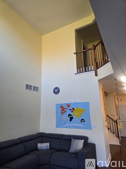 A living room with a couch and a painting on the wall.