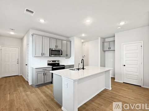 A modern kitchen with white cabinets and a central island.