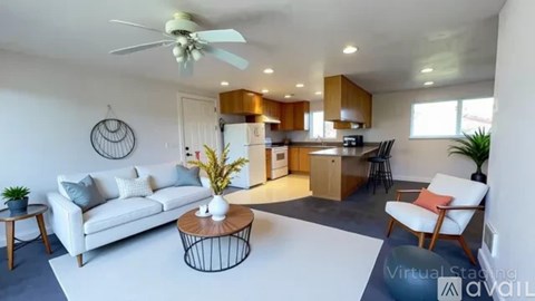 A living room with a white couch, a coffee table, and a ceiling fan.
