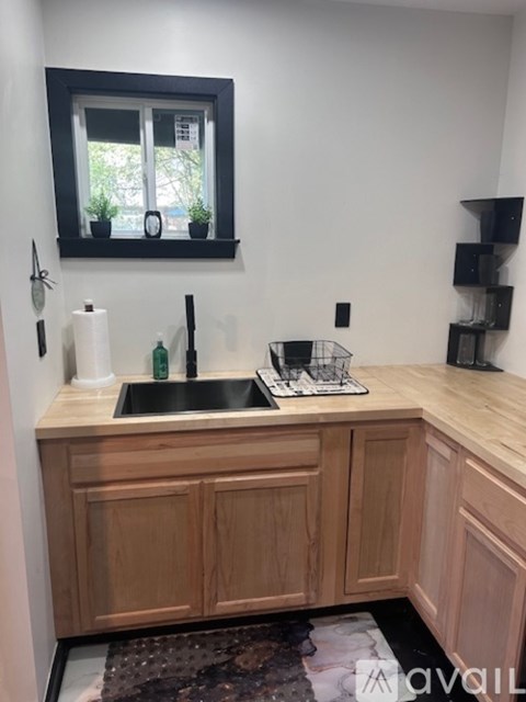 A kitchen with a sink and wooden cabinets.