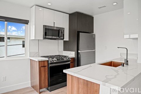 A modern kitchen with a stainless steel refrigerator and a white countertop.