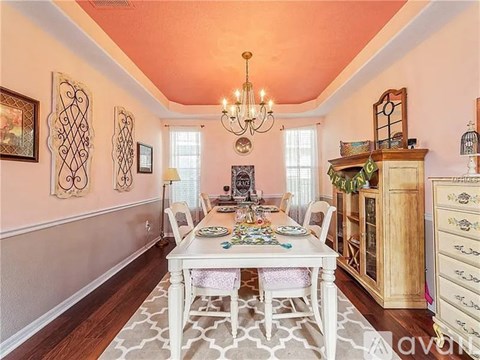 A dining room with a table set for a meal.