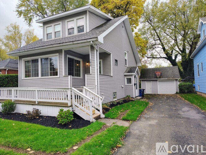 A two-story house with a grey exterior and a white porch.