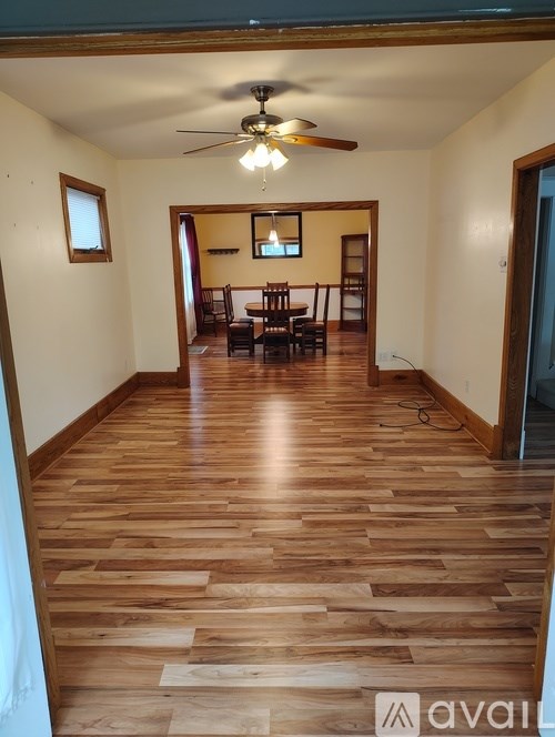 A room with wooden flooring and a ceiling fan.