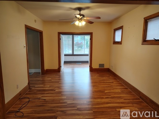 A room with wooden flooring and a ceiling fan.