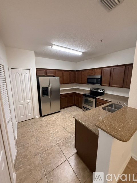 A kitchen with brown cabinets and a granite counter.
