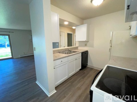 A kitchen with white cabinets and a black dishwasher.