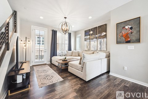 A living room with a white couch and a chandelier.