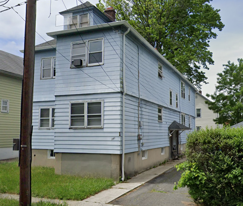 A blue house with a white door and windows.