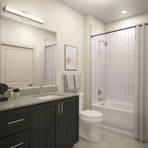 A white toilet sits in a bathroom next to a sink and a bathtub.