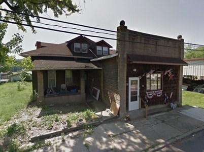 A house with a brown roof and a porch with a white door.