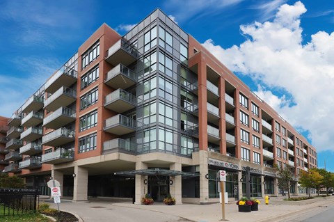 A modern apartment building with a glass facade and balconies.