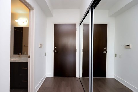 A hallway with two doors and a mirror on the left.