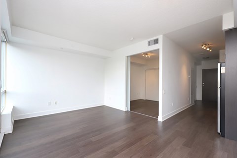 A large empty room with wooden floors and white walls.