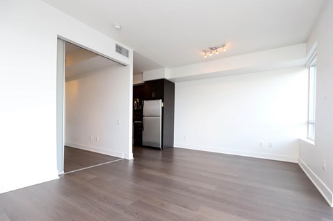 A kitchen area with a refrigerator and a doorway leading to another room.