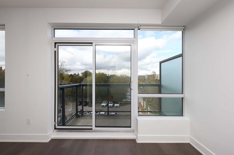 A large glass door with a view of a parking lot outside.