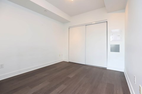 A room with a sliding door and wood flooring.