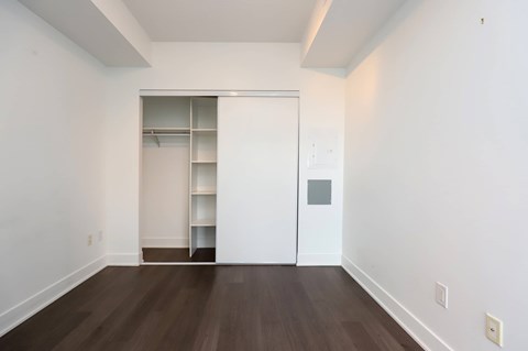 A room with a white door and a white shelving unit.