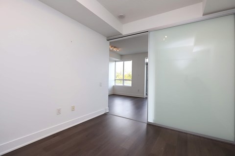 A room with a sliding glass door leading to a balcony.
