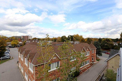 A red brick building with a tree in front of it.