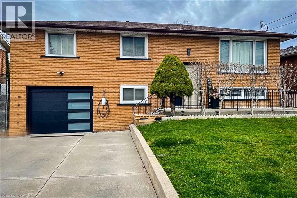 A house with a brown brick exterior and a black garage door.