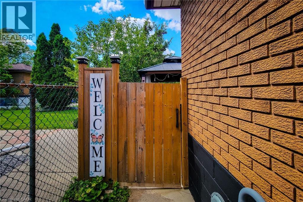 A wooden gate with a sign that says "Welcome" in front of a brick wall.