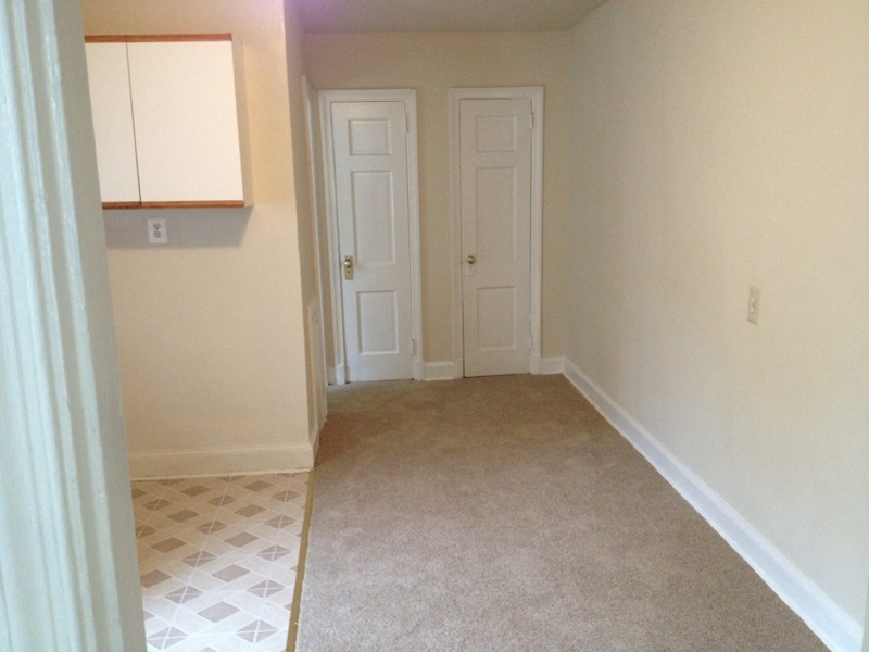 a room with a carpet and two doors