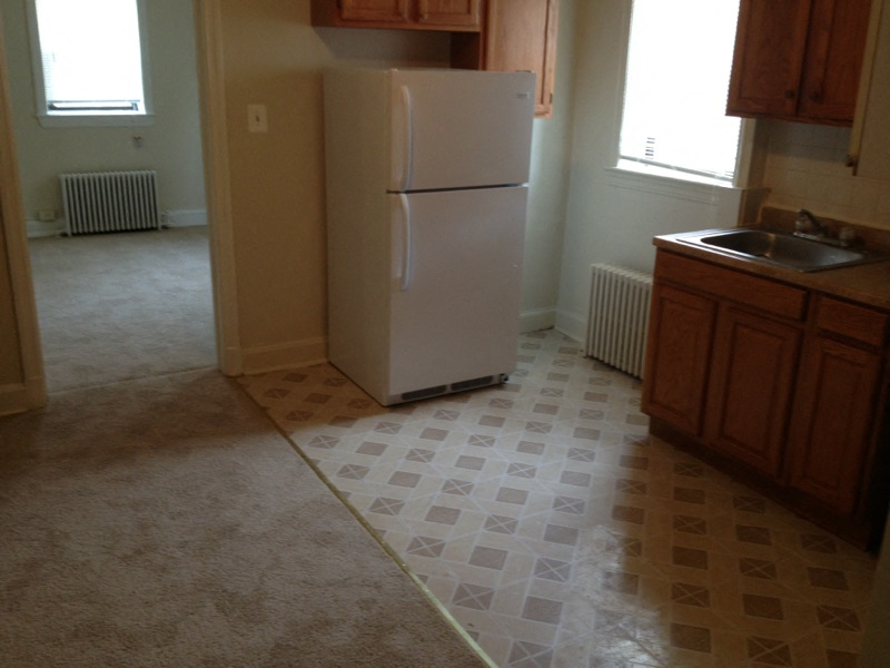 an empty kitchen with a refrigerator and a sink