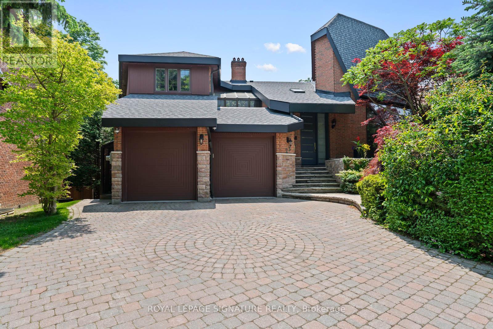 A house with a brick driveway and a grey roof.