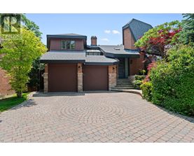 A house with a brick driveway and a grey roof.