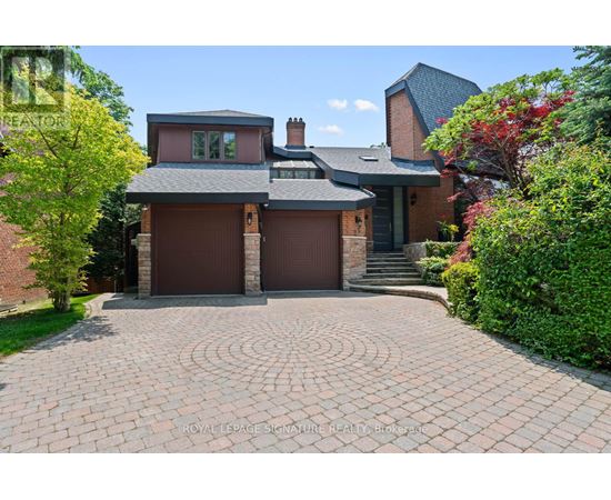 A house with a brick driveway and a grey roof.