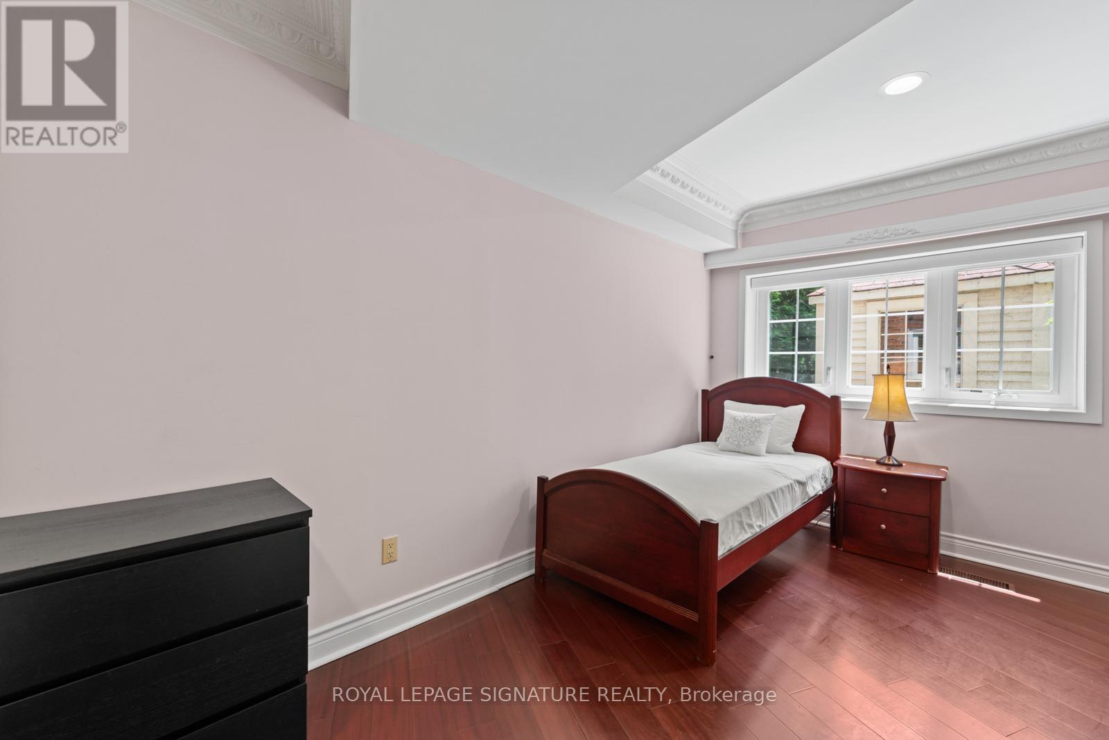 A bedroom with a bed, nightstand, and dresser.
