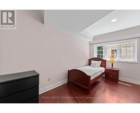 A bedroom with a bed, nightstand, and dresser.