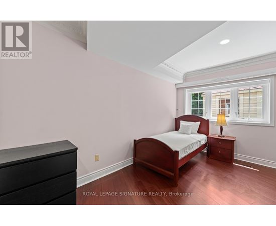 A bedroom with a bed, nightstand, and dresser.