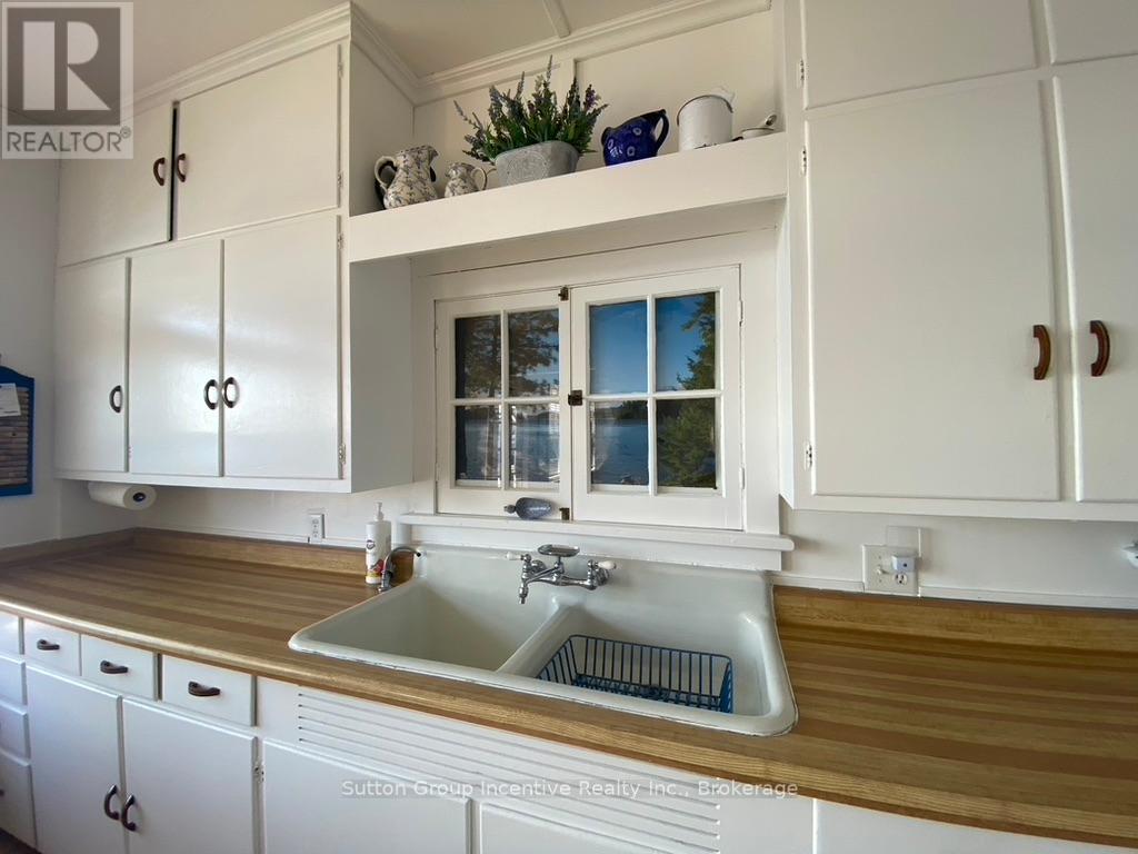 A kitchen with white cabinets and a wooden countertop.
