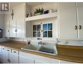 A kitchen with white cabinets and a wooden countertop.