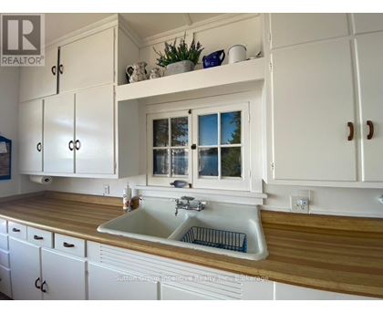 A kitchen with white cabinets and a wooden countertop.